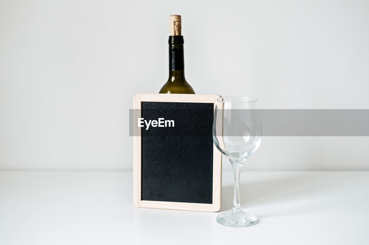 Bottle of wine, glass and empty sign mockup. bottle of wine with empty glass and blackboard mockup