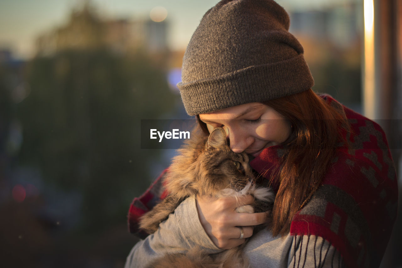 Young woman holding cat