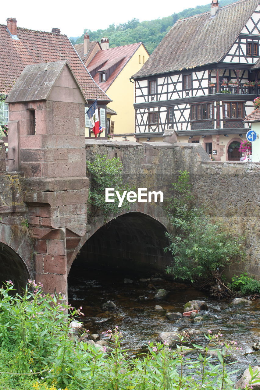 BRIDGE OVER RIVER BY OLD BUILDINGS