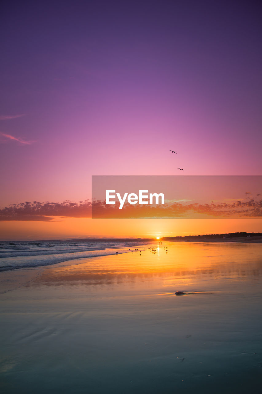 Scenic view of sea against romantic sky at sunset