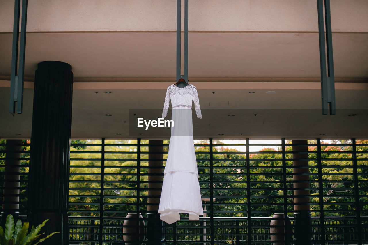 Low angle view of wedding dress hanging on building