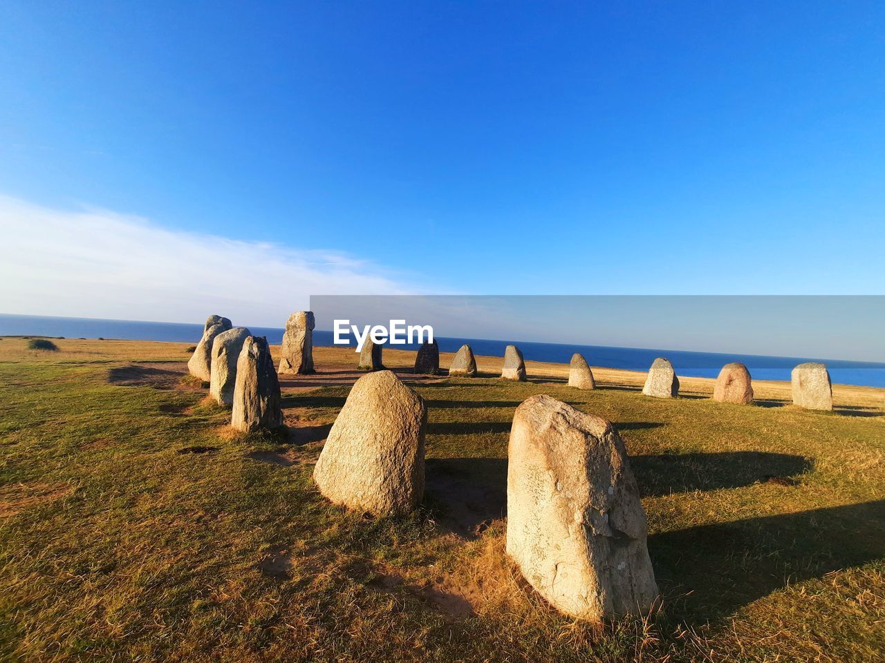 sky, horizon, land, nature, landscape, blue, sea, scenics - nature, environment, no people, tranquil scene, rock, tranquility, grass, bale, hay, hill, plant, day, sunlight, in a row, rural scene, coast, field, travel, travel destinations, beauty in nature, water, outdoors, beach, rural area, clear sky, cloud, copy space, agriculture, tourism, non-urban scene, natural environment, ancient, history, architecture, horizon over water