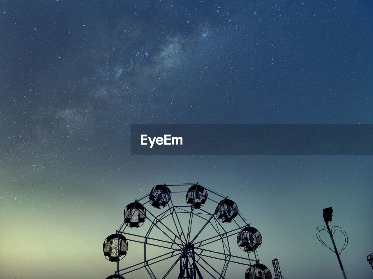 Low angle view of ferris wheel against sky at night