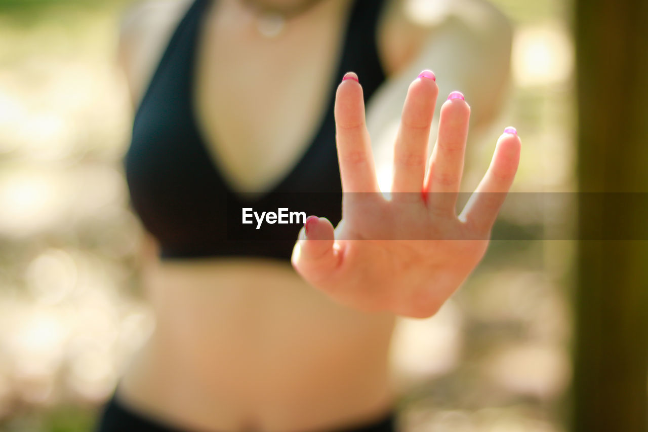 Midsection of woman gesturing stop gesture at park