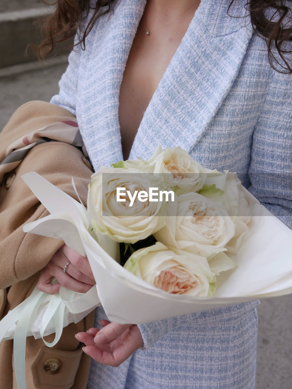 MIDSECTION OF WOMAN HOLDING BOUQUET ON WHITE ROSE