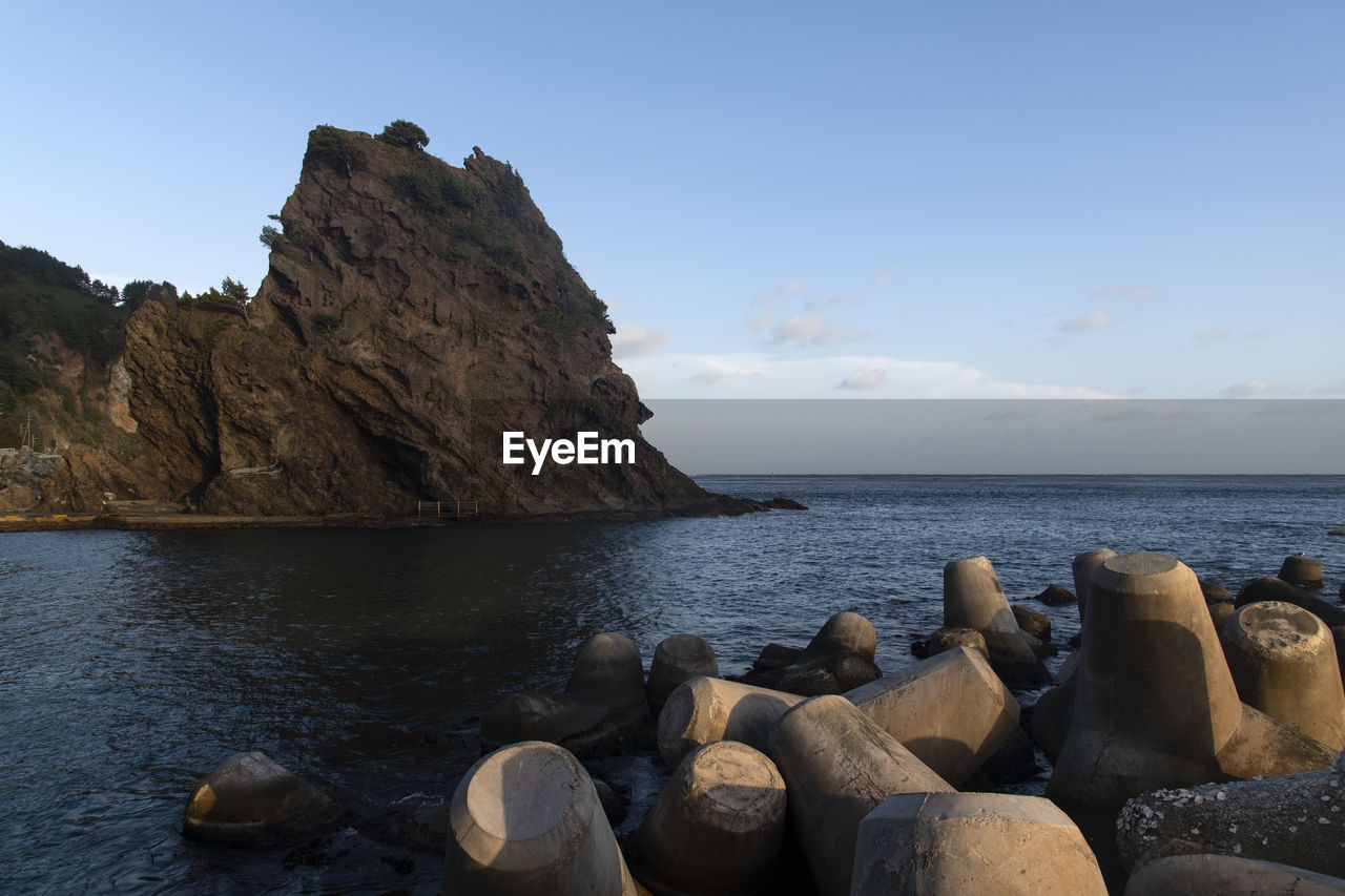 Rocks on sea shore against sky