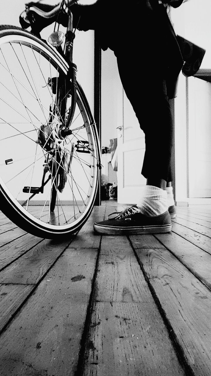 Low section of man standing by bicycle