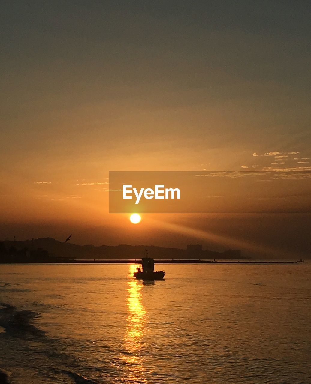 SILHOUETTE BOAT IN SEA AGAINST ORANGE SKY