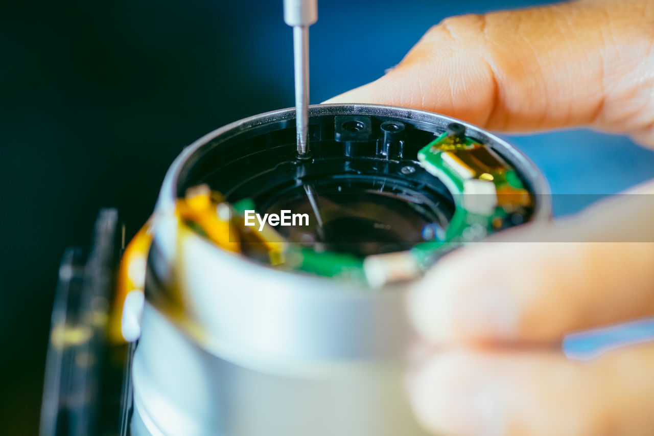 Close-up of person repairing camera lens