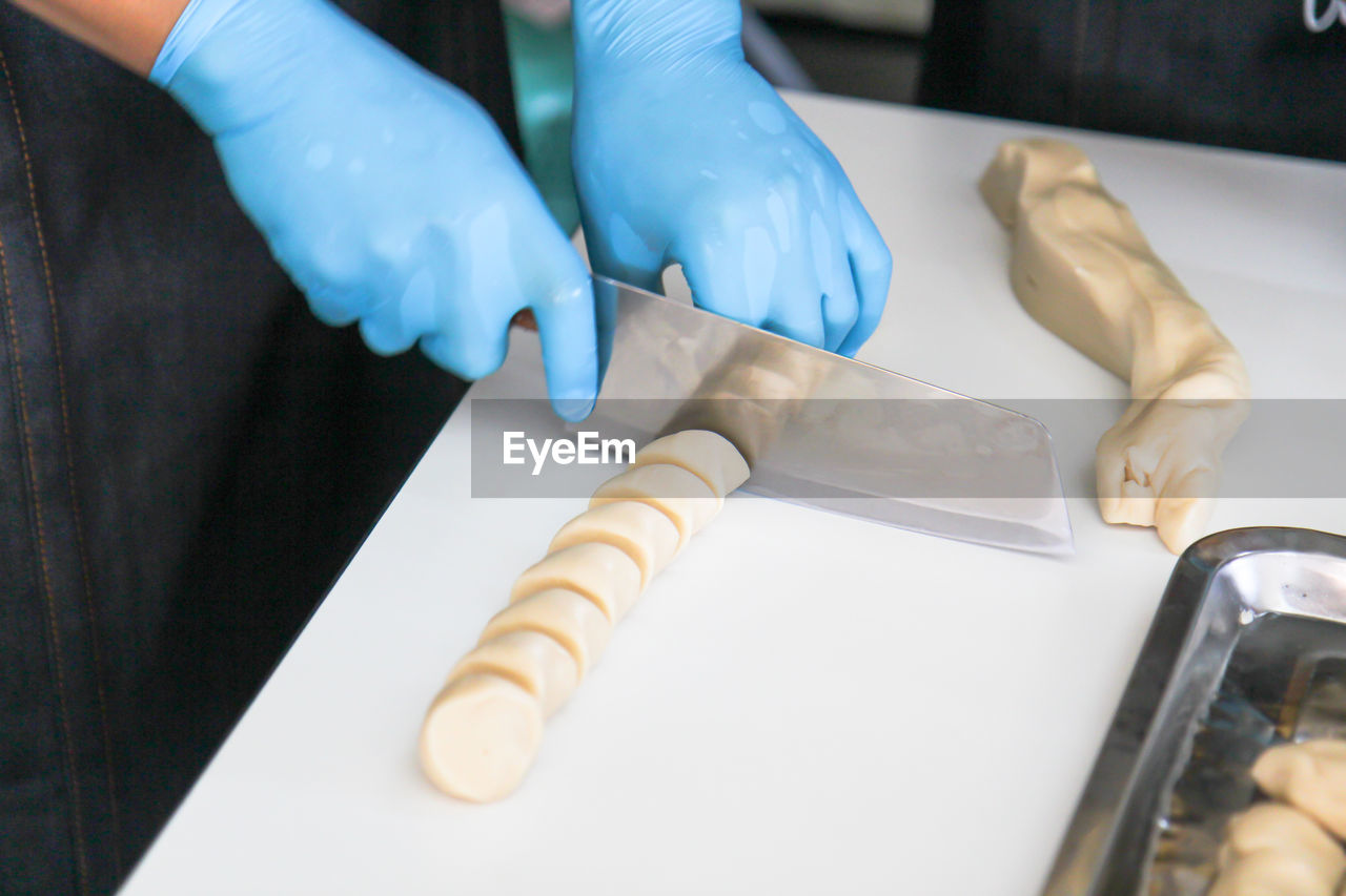 MIDSECTION OF PERSON PREPARING CAKE