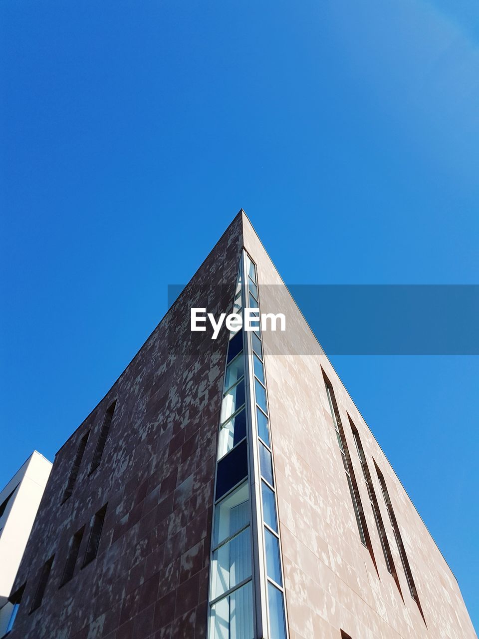 Low angle view of modern building against blue sky