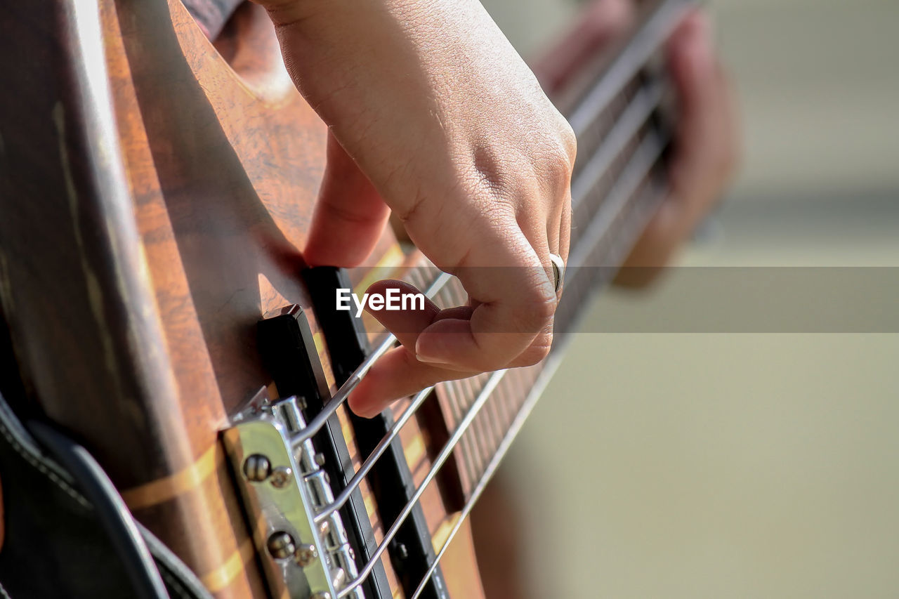 MIDSECTION OF MAN PLAYING GUITAR AT MUSIC CONCERT