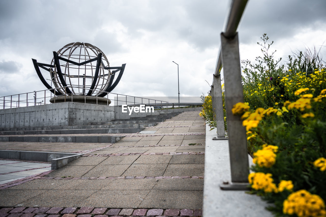 cloud, sky, flower, nature, yellow, architecture, flowering plant, plant, spring, overcast, built structure, no people, urban area, outdoors, sunlight, footpath, city, park, beauty in nature, travel destinations, day, environment