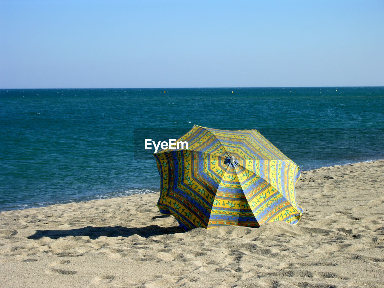 DECK CHAIR ON BEACH AGAINST CLEAR SKY