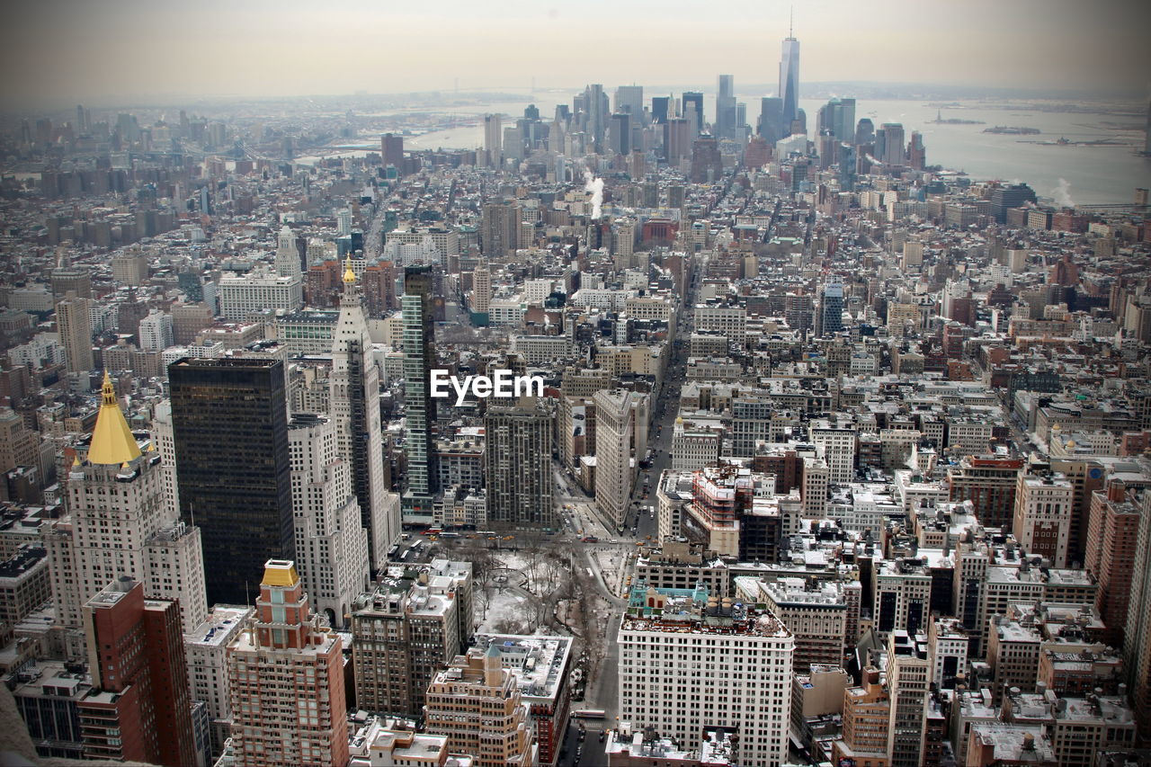 HIGH ANGLE VIEW OF MODERN CITYSCAPE AGAINST SKY