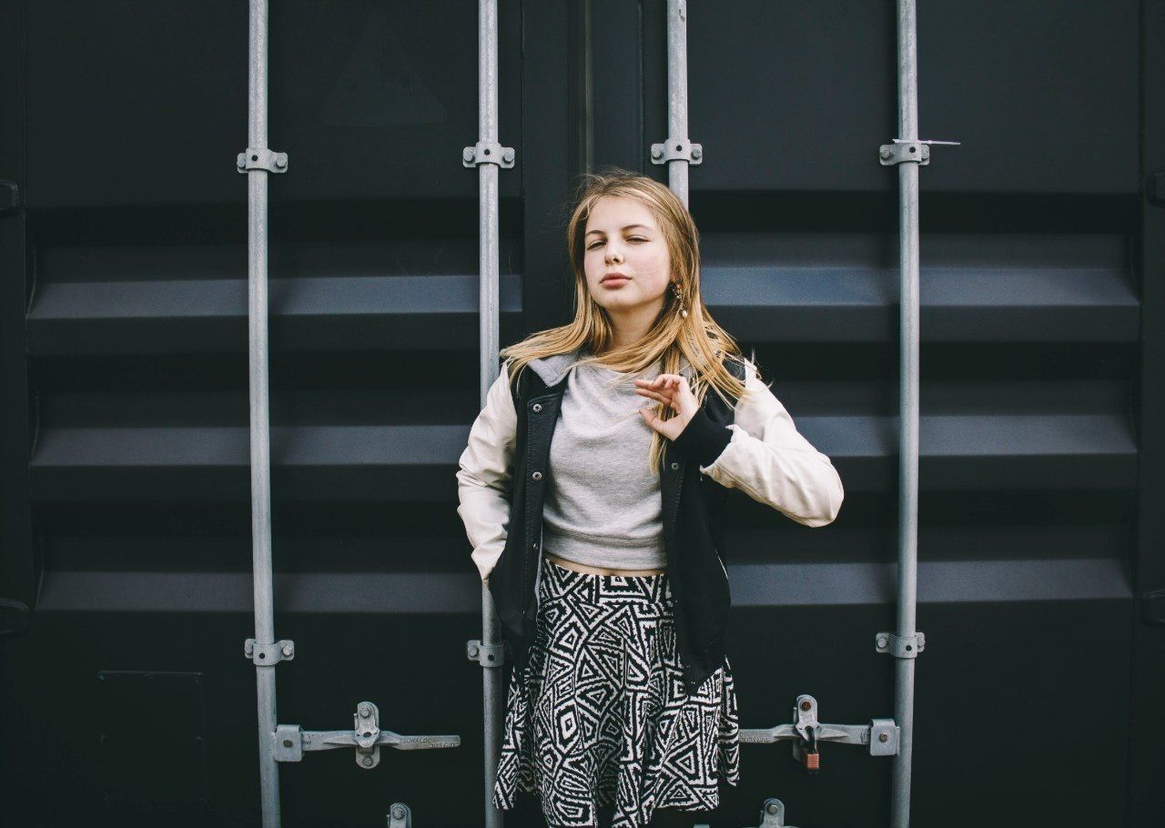 PORTRAIT OF A YOUNG WOMAN STANDING ON TILED FLOOR