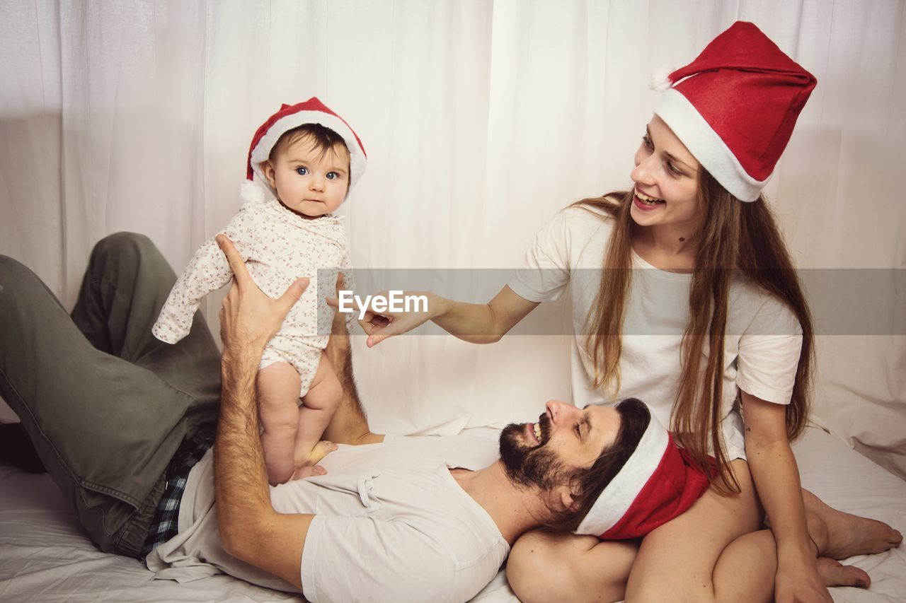 Mother and father playing with daughter at home