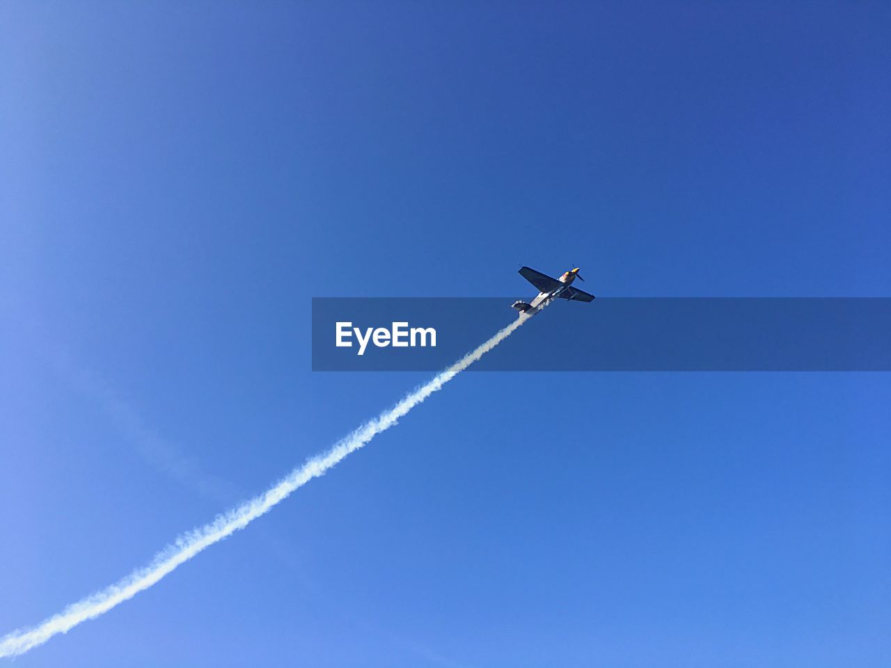 Low angle view of airplane flying in blue sky