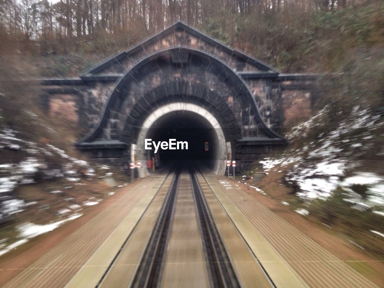 Blurred motion of railroad tracks leading towards tunnel