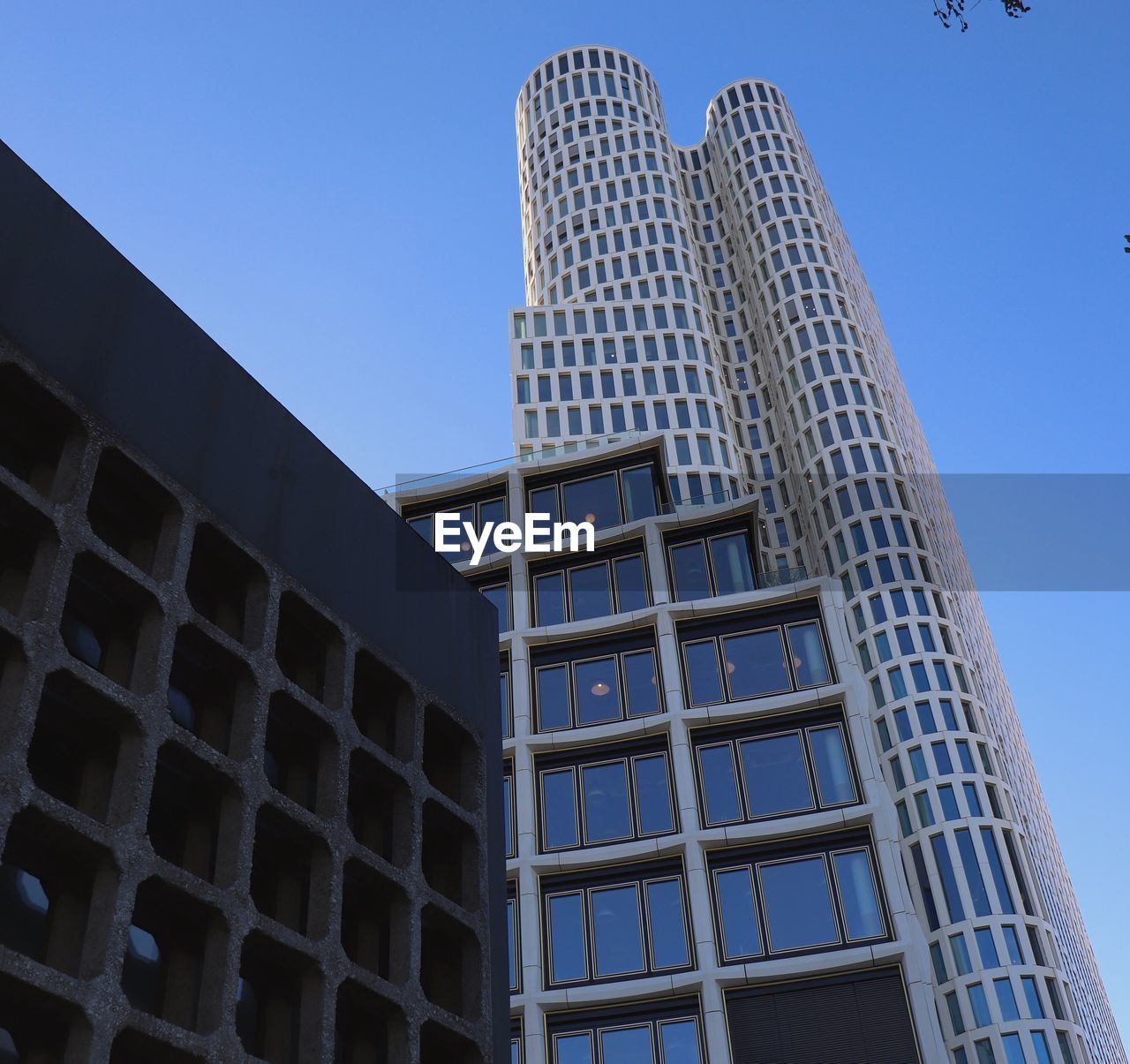 Low angle view of modern building against clear blue sky