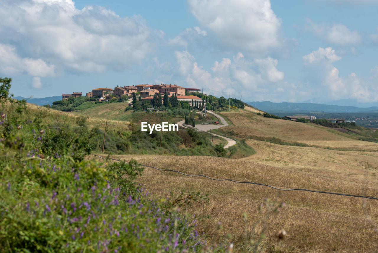 sky, hill, environment, landscape, land, nature, cloud, plant, scenics - nature, rural area, beauty in nature, grass, travel, travel destinations, architecture, plateau, meadow, grassland, sea, tourism, no people, field, coast, building, horizon, water, flower, ridge, outdoors, prairie, flowering plant, built structure, natural environment, tranquility, rural scene, non-urban scene, building exterior, day, tranquil scene, terrain, trip, vacation, coastline, cliff, holiday, beach, tree, blue, mountain range, panoramic, wilderness