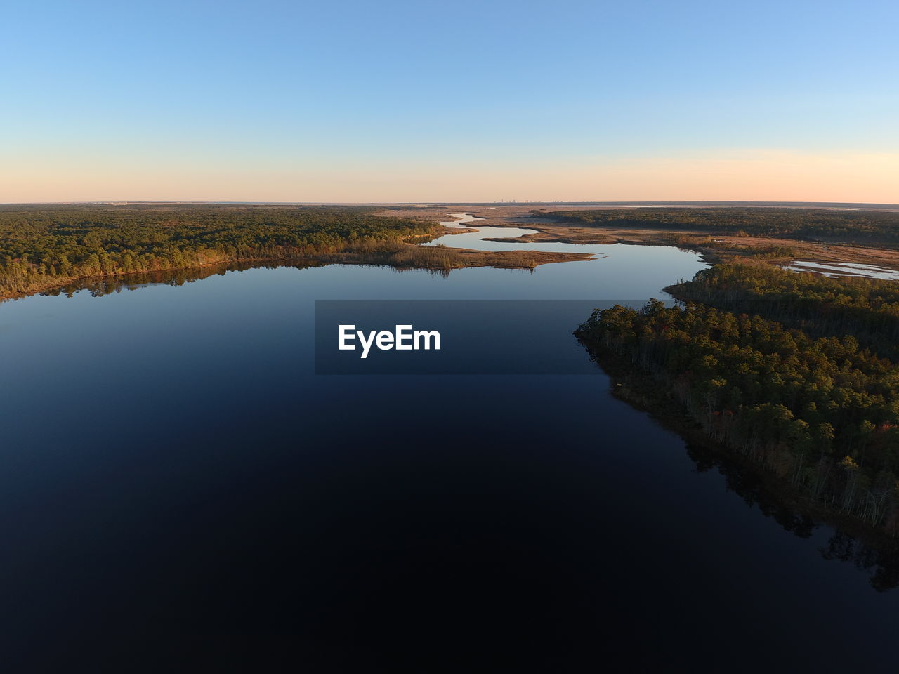 Scenic view of lake against sky during sunset