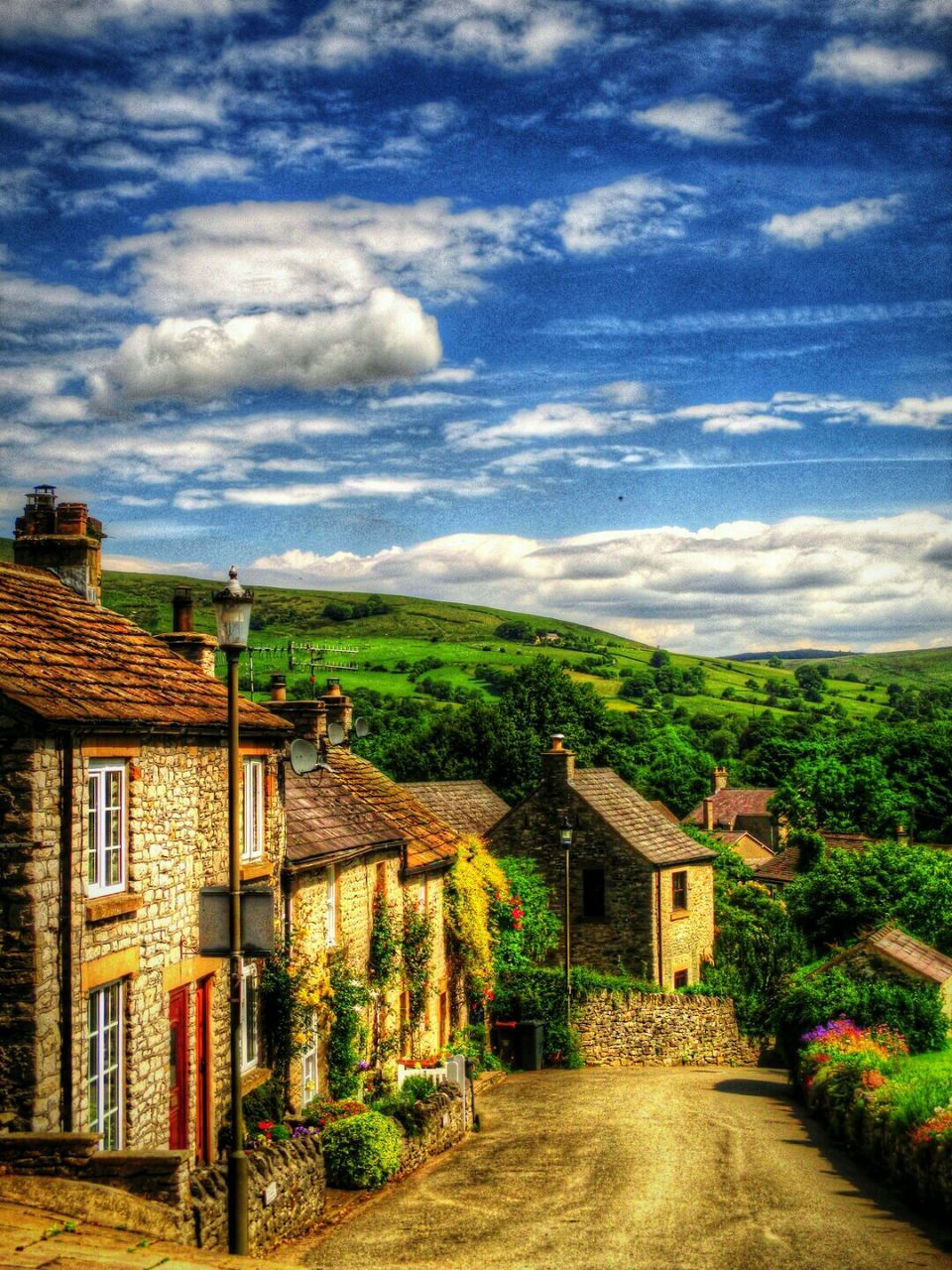 Street by houses against cloudy sky