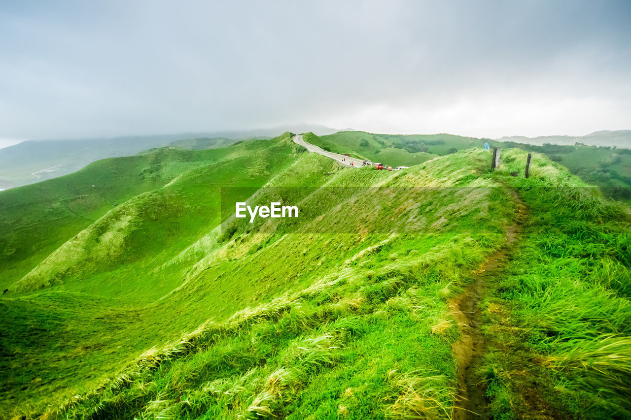 Scenic view of green landscape against sky. rolling hills of iraya, basco, batanes, philippines.