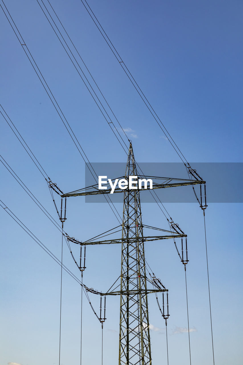 low angle view of electricity pylons against clear sky