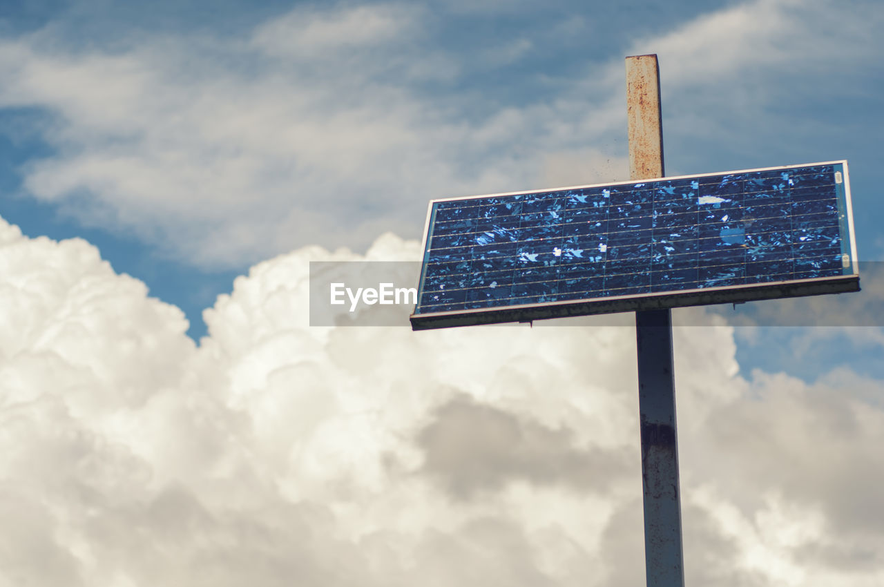 Low angle view of solar against cloudy sky