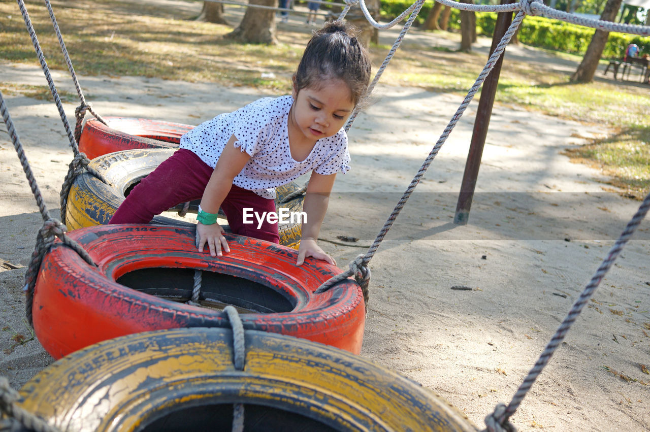 FULL LENGTH OF GIRL PLAYING ON PLAYGROUND