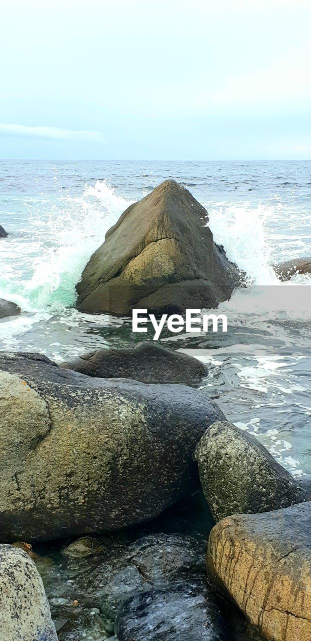 SCENIC VIEW OF ROCKS ON BEACH AGAINST SKY