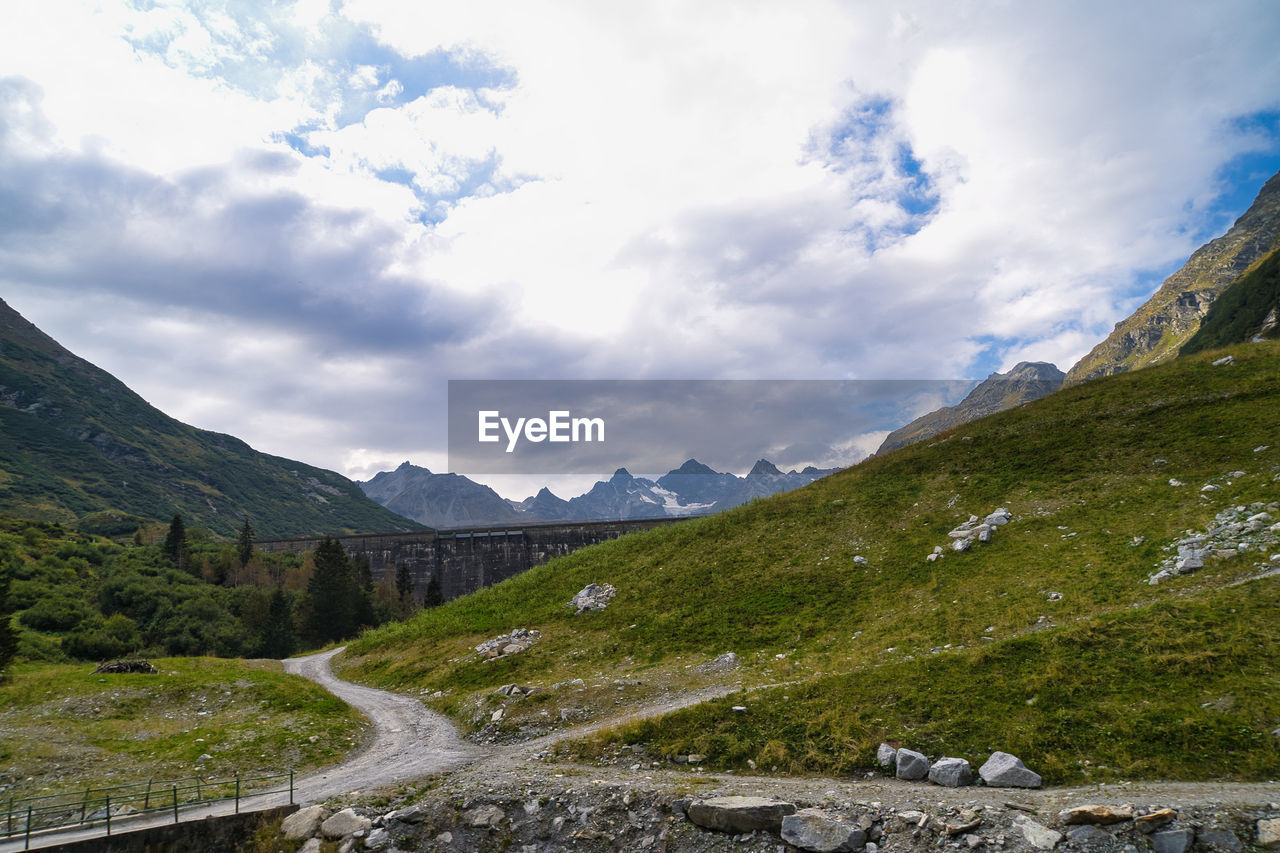 SCENIC VIEW OF ROAD AMIDST MOUNTAINS AGAINST SKY