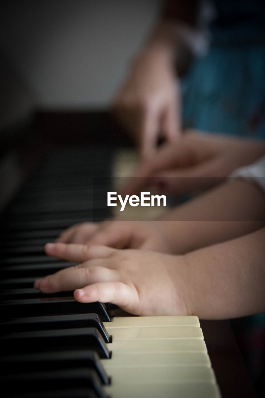 Cropped image of hands playing piano