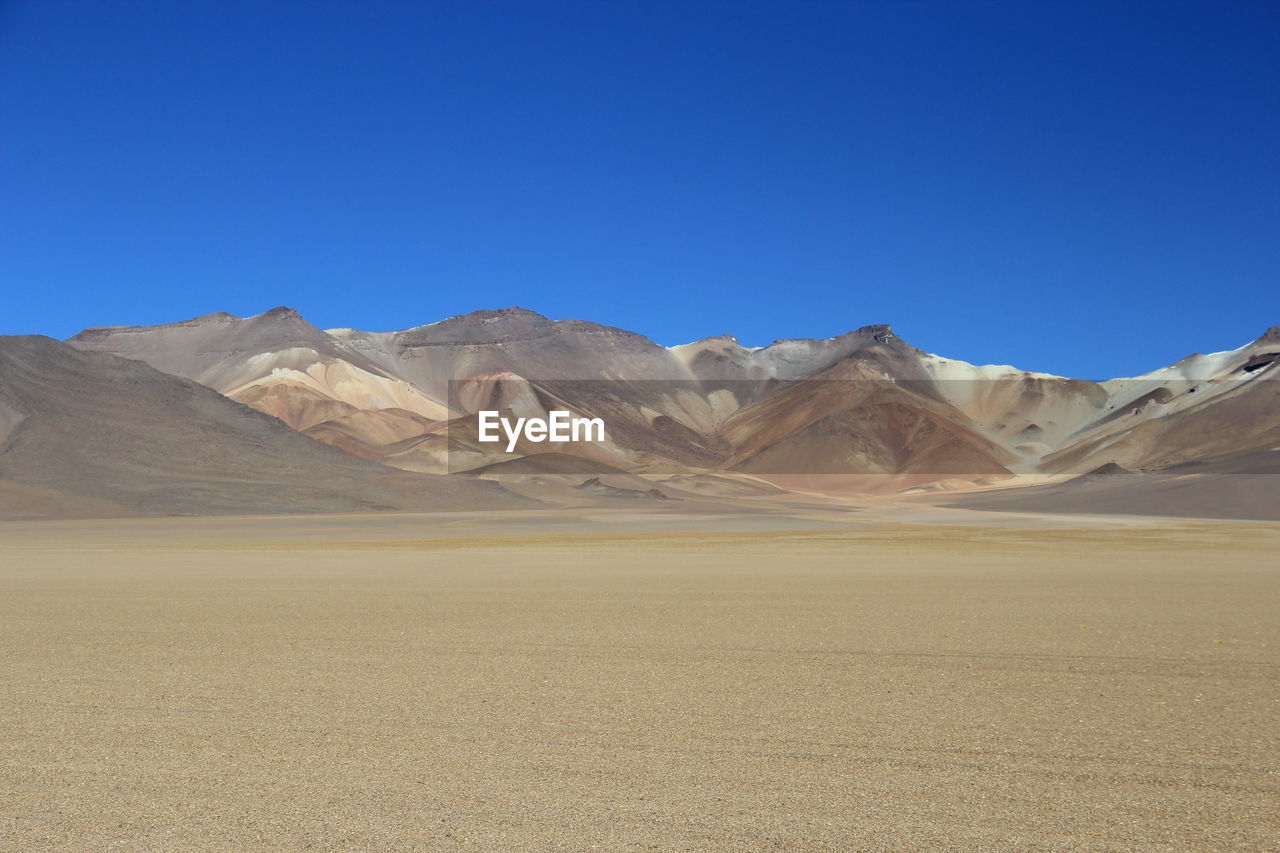 Scenic view of mountain against blue sky