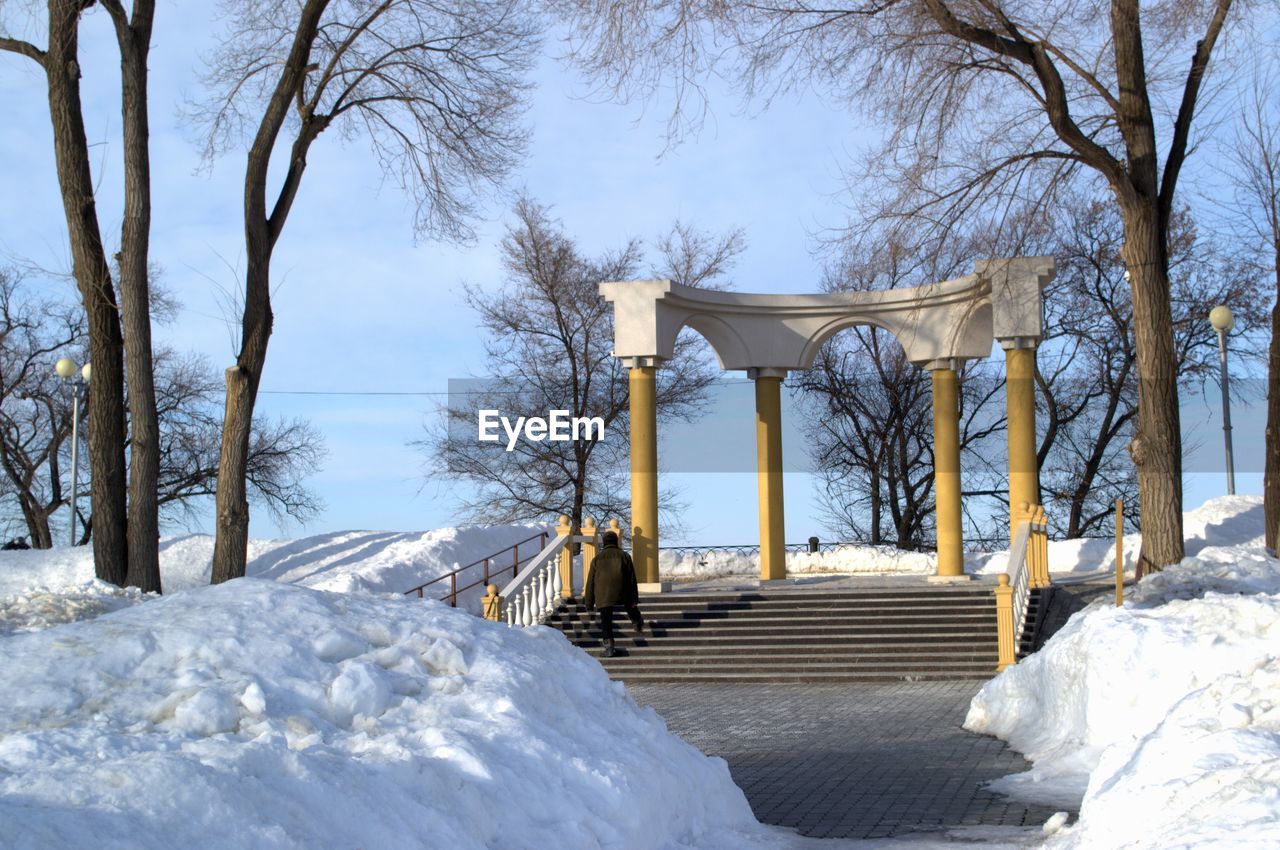 SNOW COVERED STAIRCASE AGAINST SKY