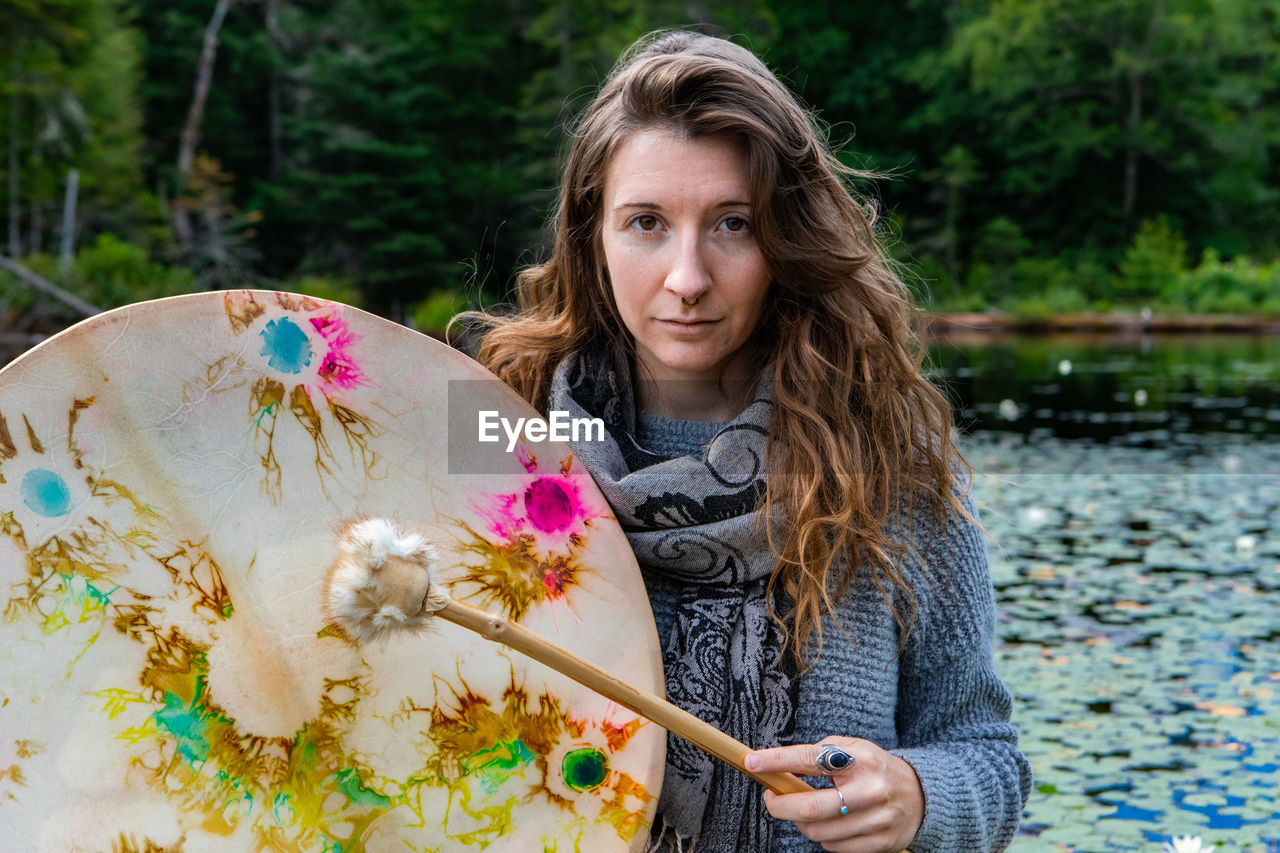 PORTRAIT OF A SMILING YOUNG WOMAN WITH WATER