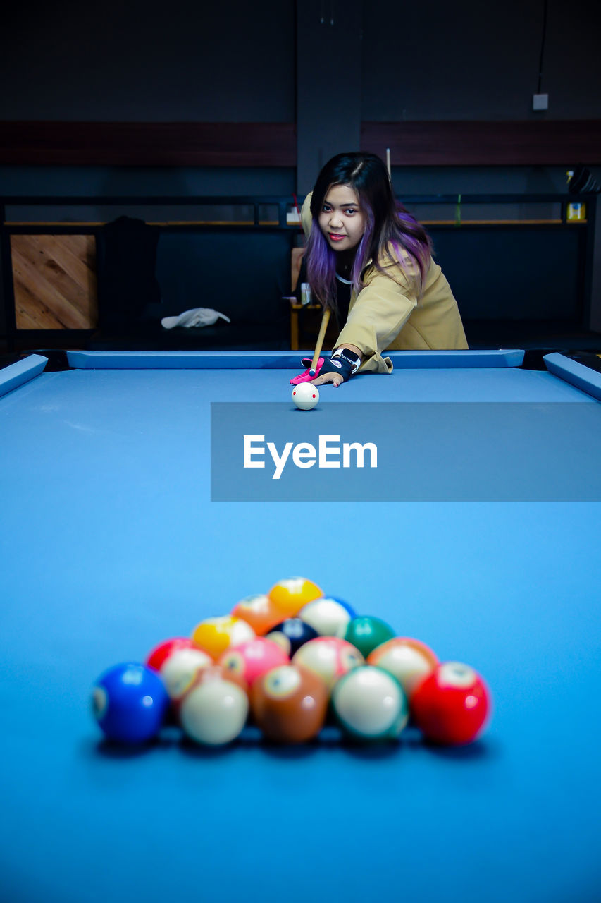 portrait of smiling boy playing pool