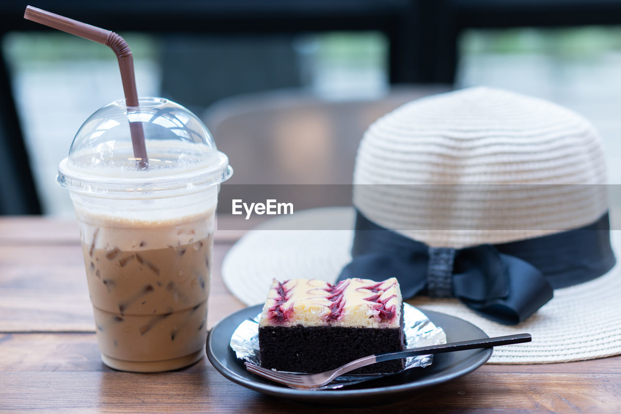 CLOSE-UP OF CHOCOLATE CAKE WITH COFFEE ON TABLE