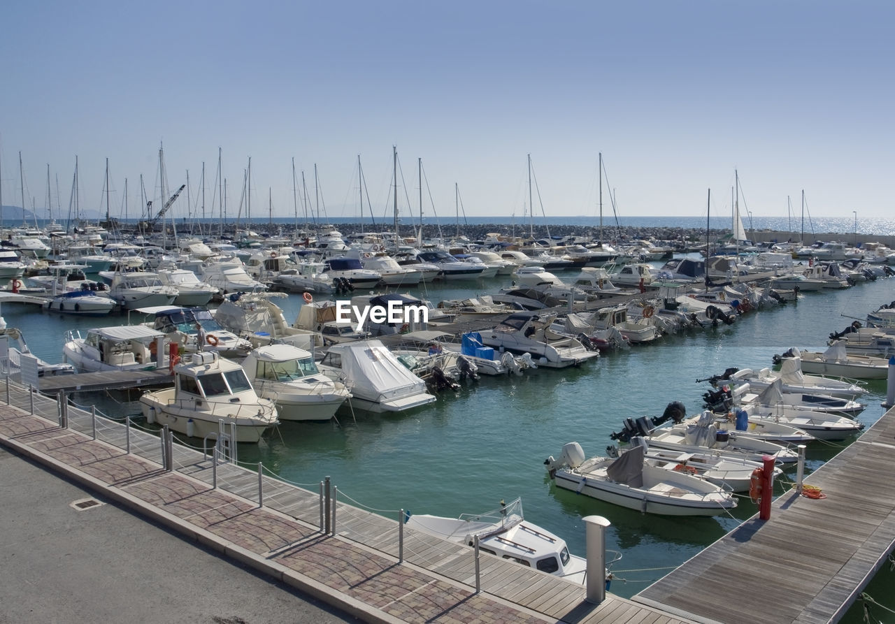 BOATS MOORED AT HARBOR