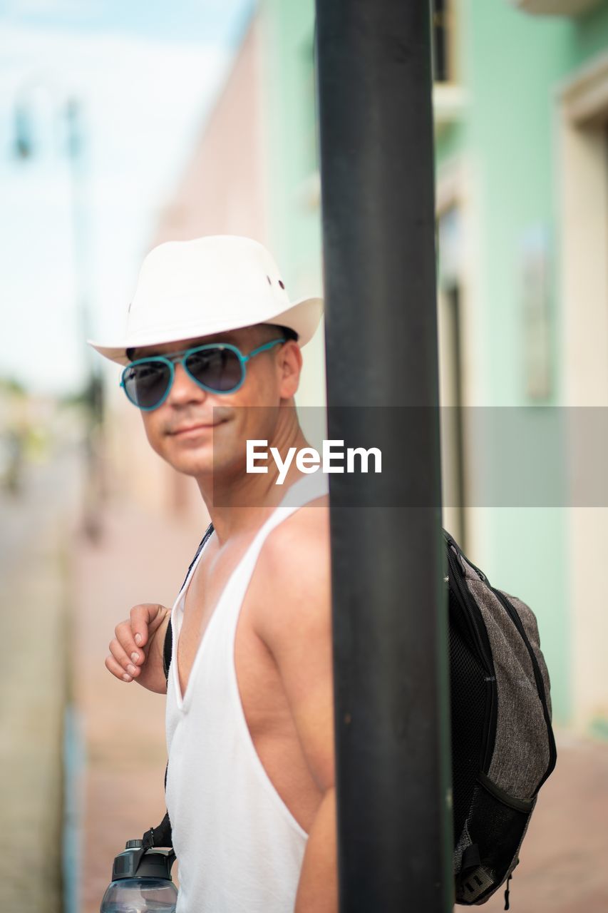 one person, adult, sunglasses, sports, lifestyles, clothing, fashion, glasses, architecture, young adult, day, goggles, smiling, hat, portrait, exercising, fashion accessory, spring, women, standing, happiness, outdoors, city, leisure activity, person, waist up, focus on foreground, helmet, strength, vitality, headwear, men, eyewear, technology