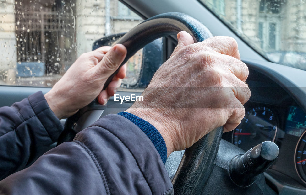 CLOSE-UP OF MAN HOLDING CAR