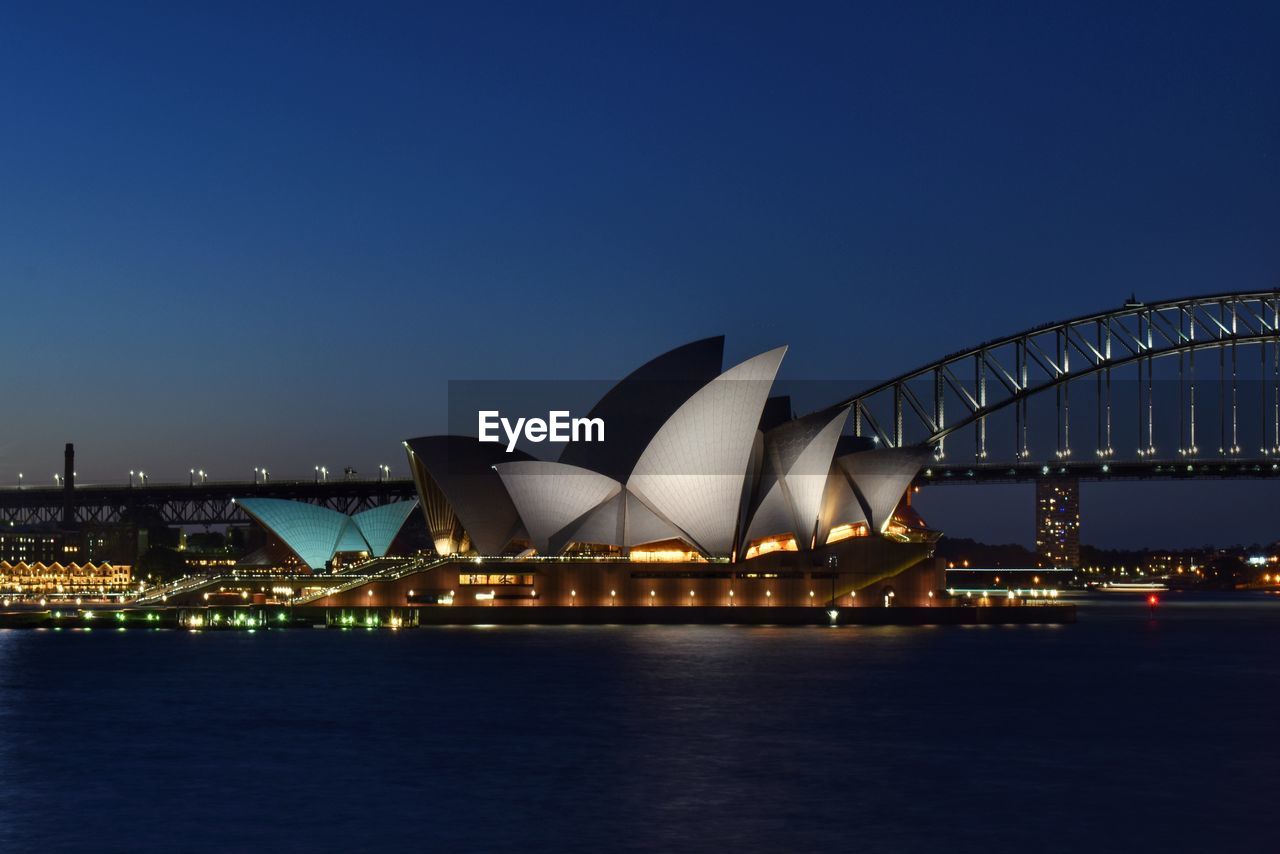 ILLUMINATED CITY AGAINST CLEAR BLUE SKY