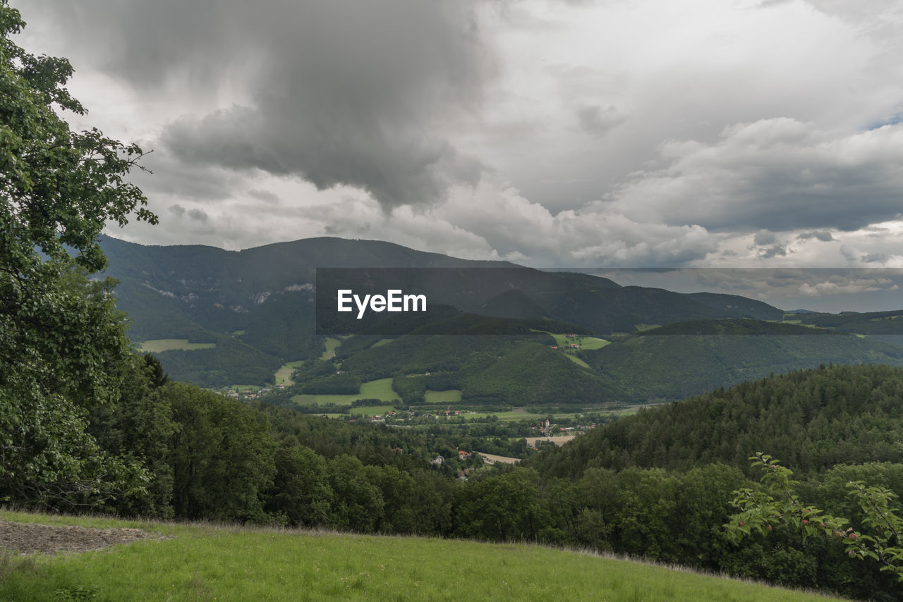 SCENIC VIEW OF GREEN LANDSCAPE AND MOUNTAINS AGAINST SKY