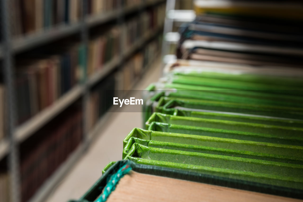 CLOSE-UP OF BOOKS ON SHELF AT LIBRARY