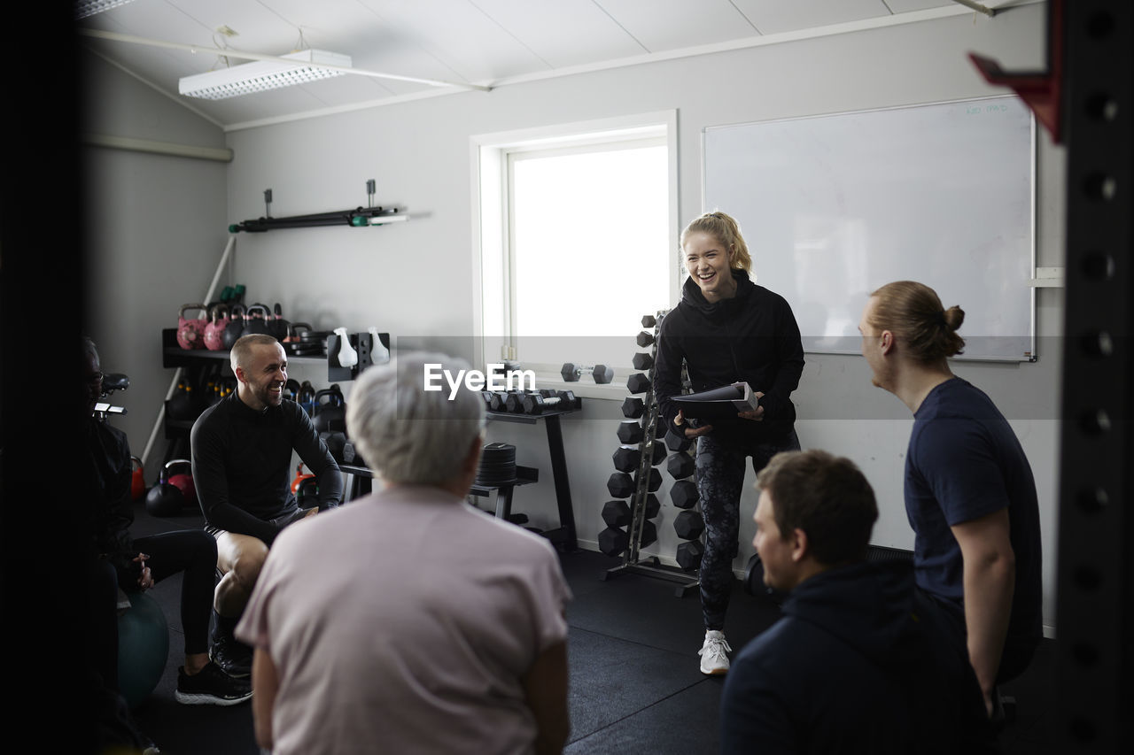 Smiling people talking together in gym