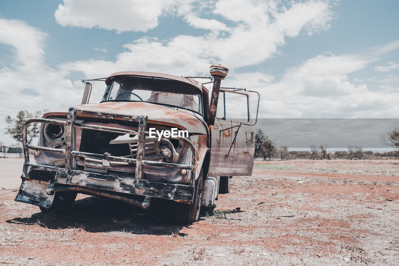 ABANDONED CAR ON FIELD