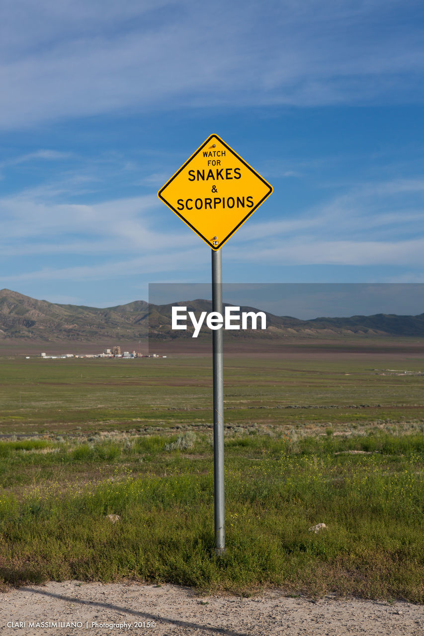 INFORMATION SIGN ON ROAD BY LAND AGAINST SKY