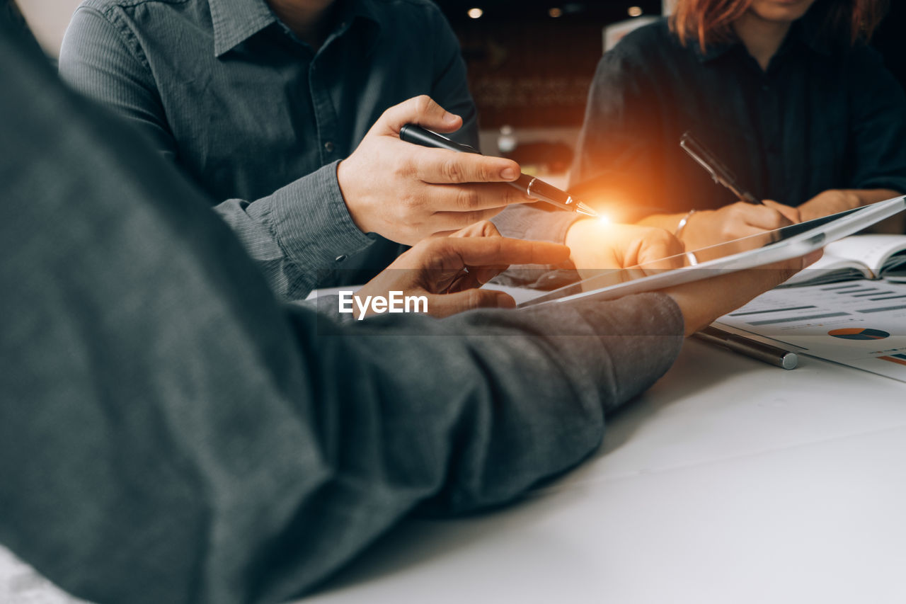 MIDSECTION OF MAN HOLDING MOBILE PHONE