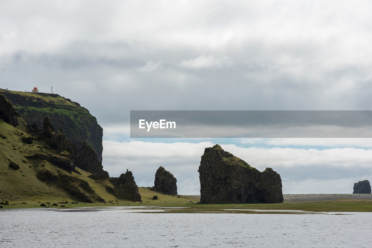 Rock formations by sea against sky